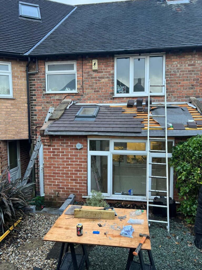 This is a photo of a roof extension that is having new roof tiles installed. This is a photo taken from the roof ridge looking down a tiled pitched roof on to a flat roof. Works carried out by South Normanton Roofing Repairs