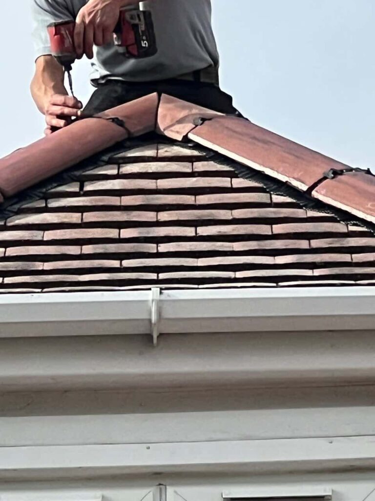 This is a photo of one of the operatives of South Normanton Roofing Repairs installing new ridge tiles